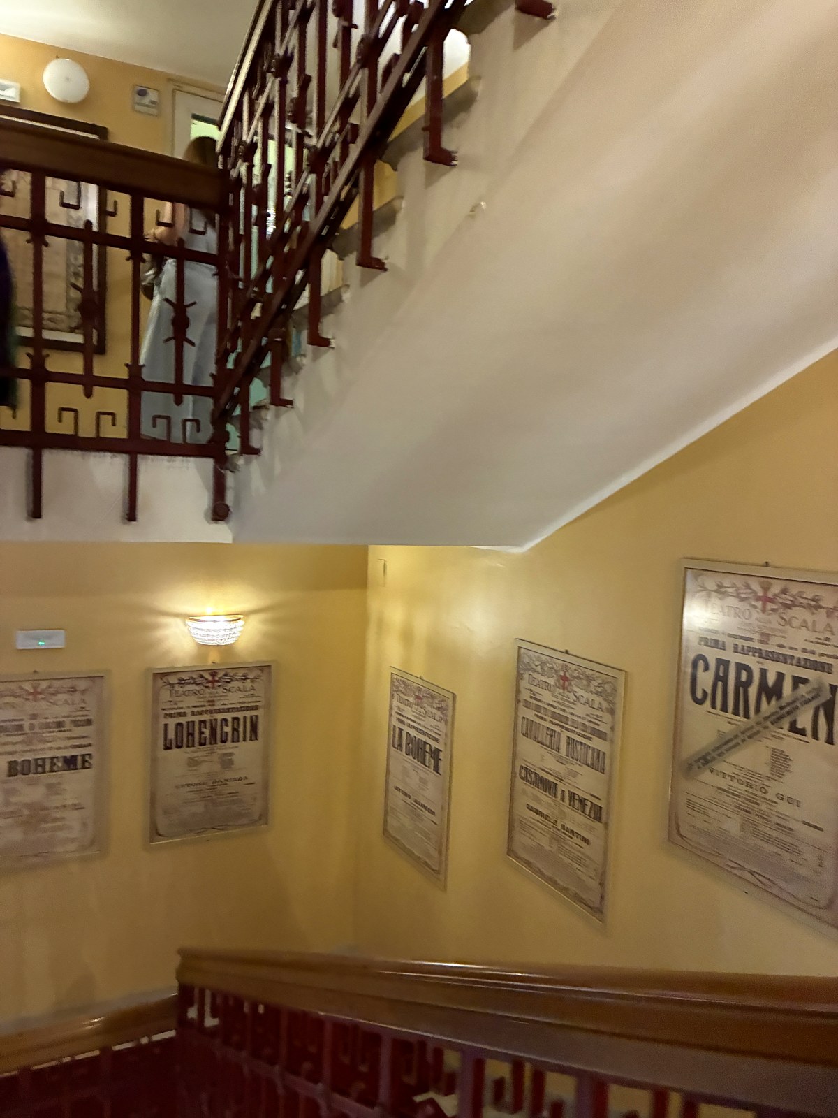 Historic opera posters on the staircase wall at La Scala, Milan