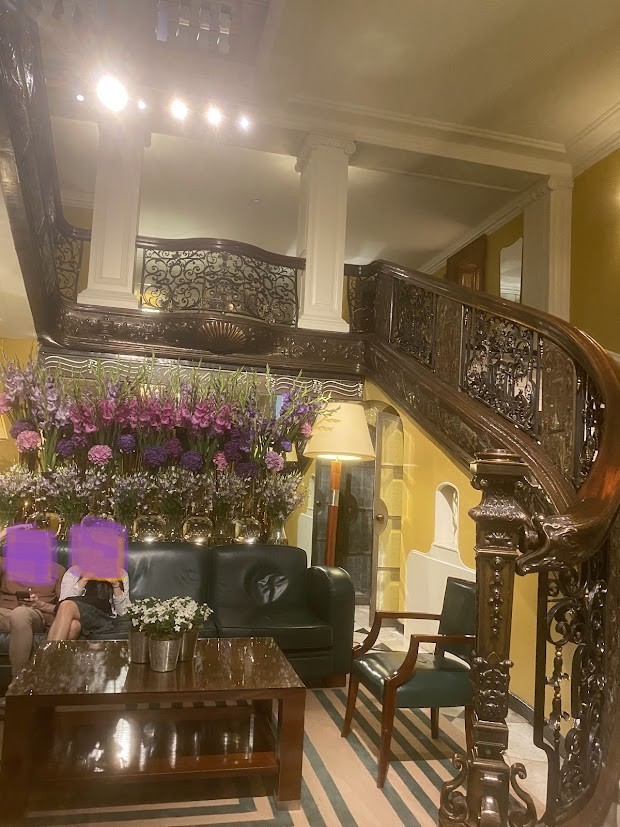 The grand staircase at Claridge’s, London, with a large floral arrangement